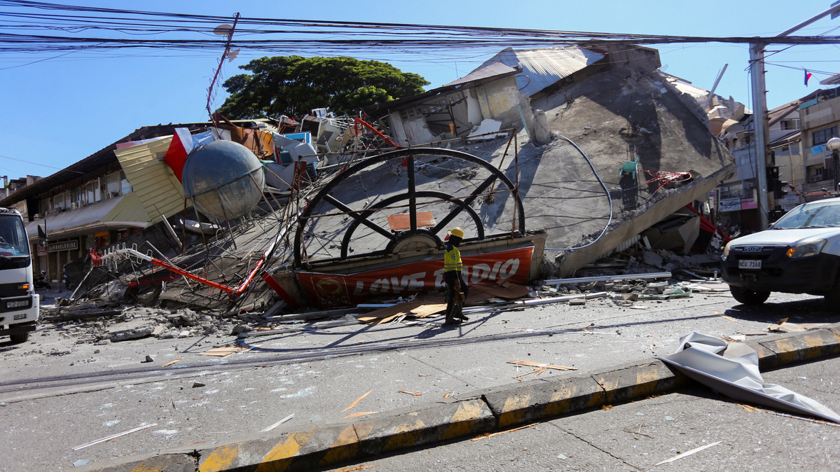 A worker walks near a collapsed building following the magnitude 7.8 quake in General Santos, southern Philippines, June 8, 2026. REUTERS/Manman Dejeto