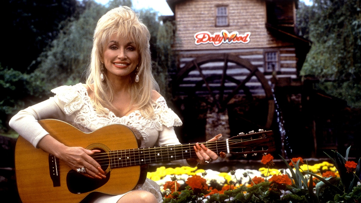 PIGEON FORGE, TN - 1993:  American singer and songwriter Dolly Parton poses for a portrait with her guitar at Dollywood circa 1993 in Pigeon Forge, Tennessee.  (Photo by Ron Davis/Getty Images)