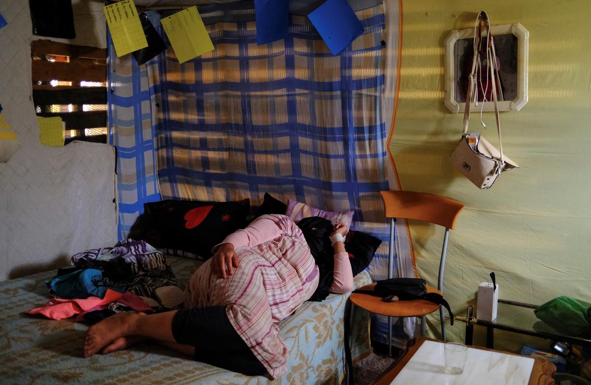 An undocumented migrant from Morocco rests at her bed at her shack in a shanty town after returning from her work inside a plastic-covered greenhouse in Almeria province, home to Europe’s largest concentration of agricultural greenhouses, in Nijar, Spain, May 5, 2026. Undocumented migrants there live without reliable electricity and with limited access to water. REUTERS/Nacho Doce