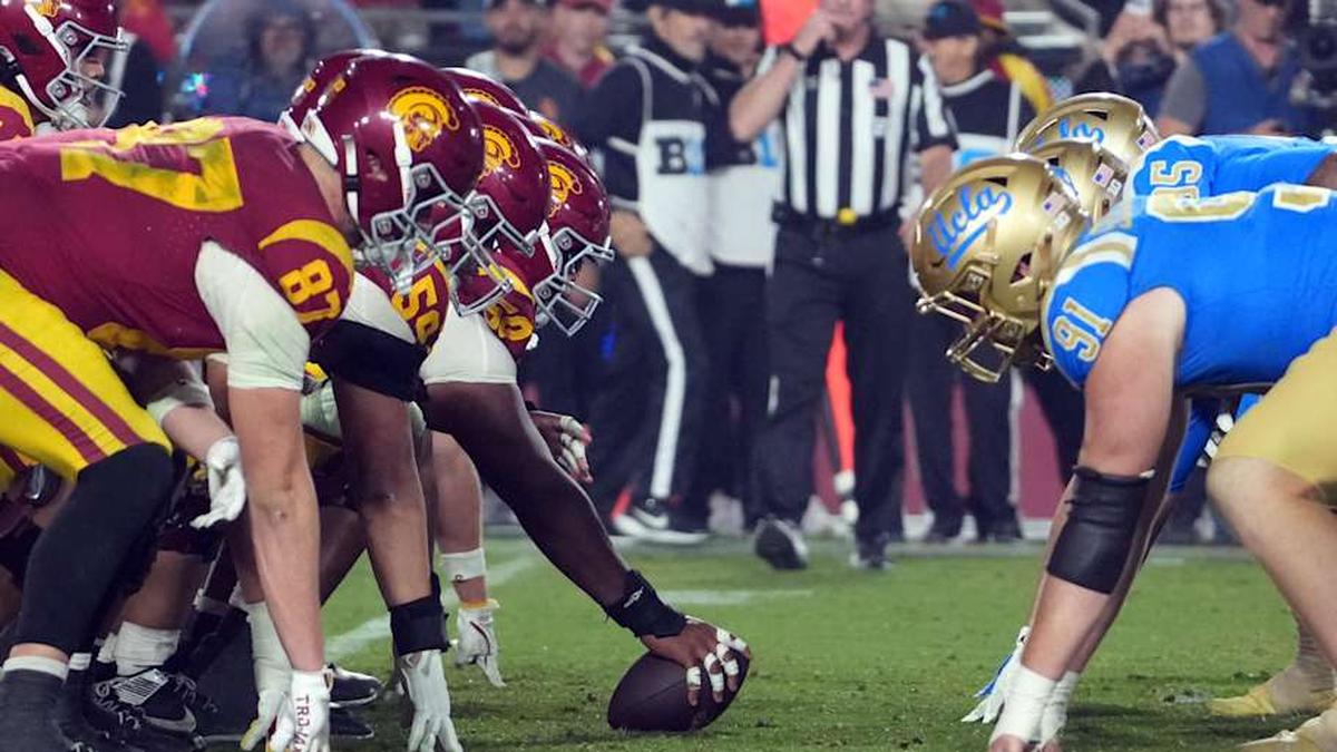  Nov 29, 2025; Los Angeles, California, USA; Helmets at the line of scrimmage as Southern California Trojans offensive lineman J'Onre Reed (50) snaps the ball against the UCLA Bruins in the second half at United Airlines Field at Los Angeles Memorial Coliseum. Mandatory Credit: Kirby Lee-Imagn Images | Kirby Lee-Imagn Images 