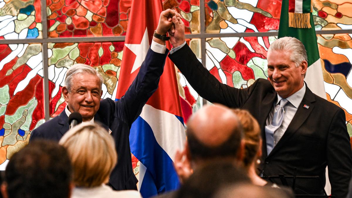 El gobernante cubano Miguel Díaz-Canel, a la , y el presidente mexicano, Andrés Manuel López Obrador, a la izquierda, levantan los brazos durante una ceremonia de entrega de la orden José Martí al presidente López Obrador, en el Palacio de la Revolución en La Habana, Cuba, el domingo 8 de mayo de 2022 (Yamil Lage/Foto vía AP)