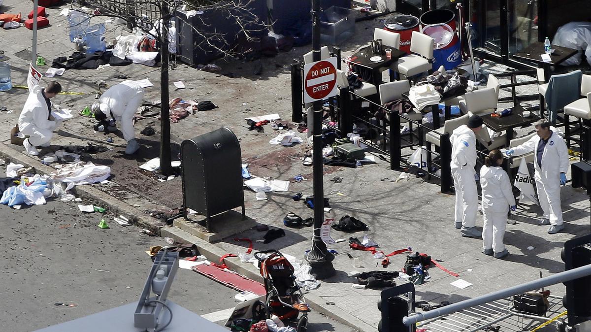 An April 16, 2013, file photo shows investigators examining the scene of the bombing near the finish line of the 2013 Boston Marathon, a day after two blasts killed three and injured more than 260 people.