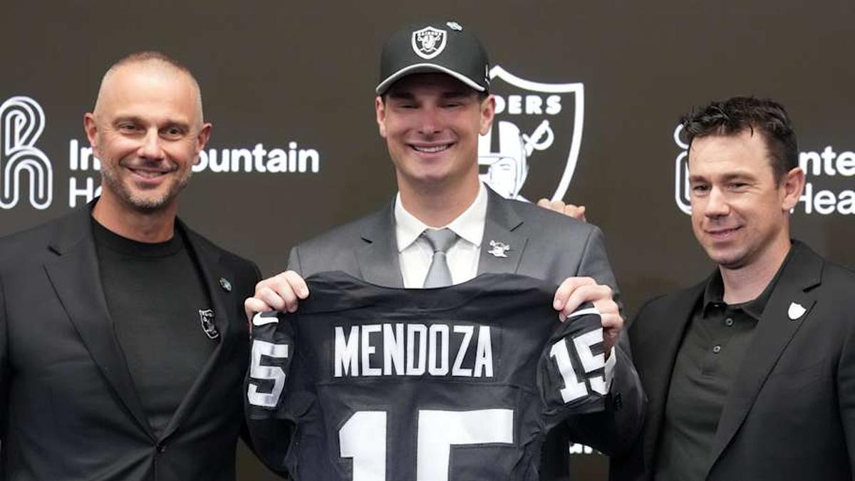  Apr 24, 2026; Henderson, NV, USA; Las Vegas Raiders quarterback Fernando Mendoza (center) poses with jersey at introductory press conference at Intermountain Health Performance Center flanked by general manager John Spytek (left) and head coach Klint Kubiak after being selected as the No. 1 pick in the 2026 NFL Draft. Mandatory Credit: Kirby Lee-Imagn Images | Kirby Lee-Imagn Images 