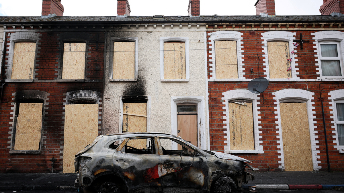 A burnt car stands in front of a boarded up house, in the aftermath of anti-immigrant protests following a knife attack on June 8, which left a man seriously injured and prompted police to declare a critical incident, at Lendrick street, east Belfast, Northern Ireland, June 10, 2026. REUTERS/Isabel Infantes