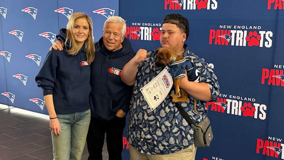  New England Patriots owner Robert Kraft and Dr. Dana Kraft pose for a photo with a new dog owner. | Ethan Hurwitz / Patriots On SI 