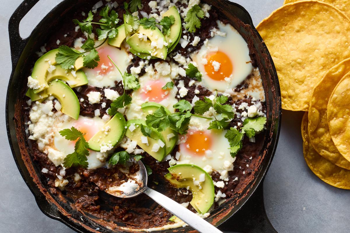 Huevos enfrijolados (eggs in spicy black beans). This recipe from Rick Martínez, which is featured in "Veg Everything," is an unbeatable way to have eggs for dinner. Food styled by Barrett Washburne. (Ghazalle Badiozamani/The New York Times)