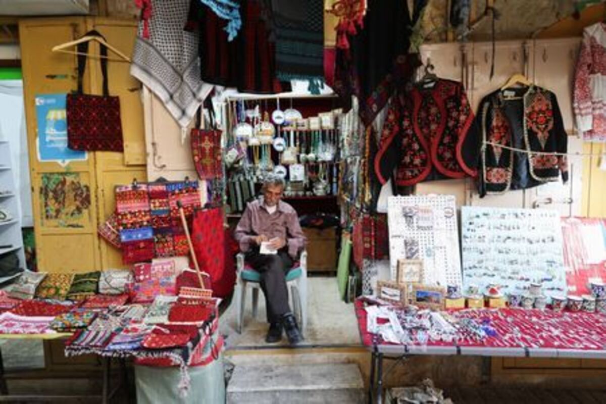 A man sits at a shop in a market near the Ibrahimi Mosque, also known as the Cave of Patriarchs, in the old city of Hebron, in the Israeli-occupied West Bank, June 17, 2026. REUTERS/Ammar Awad