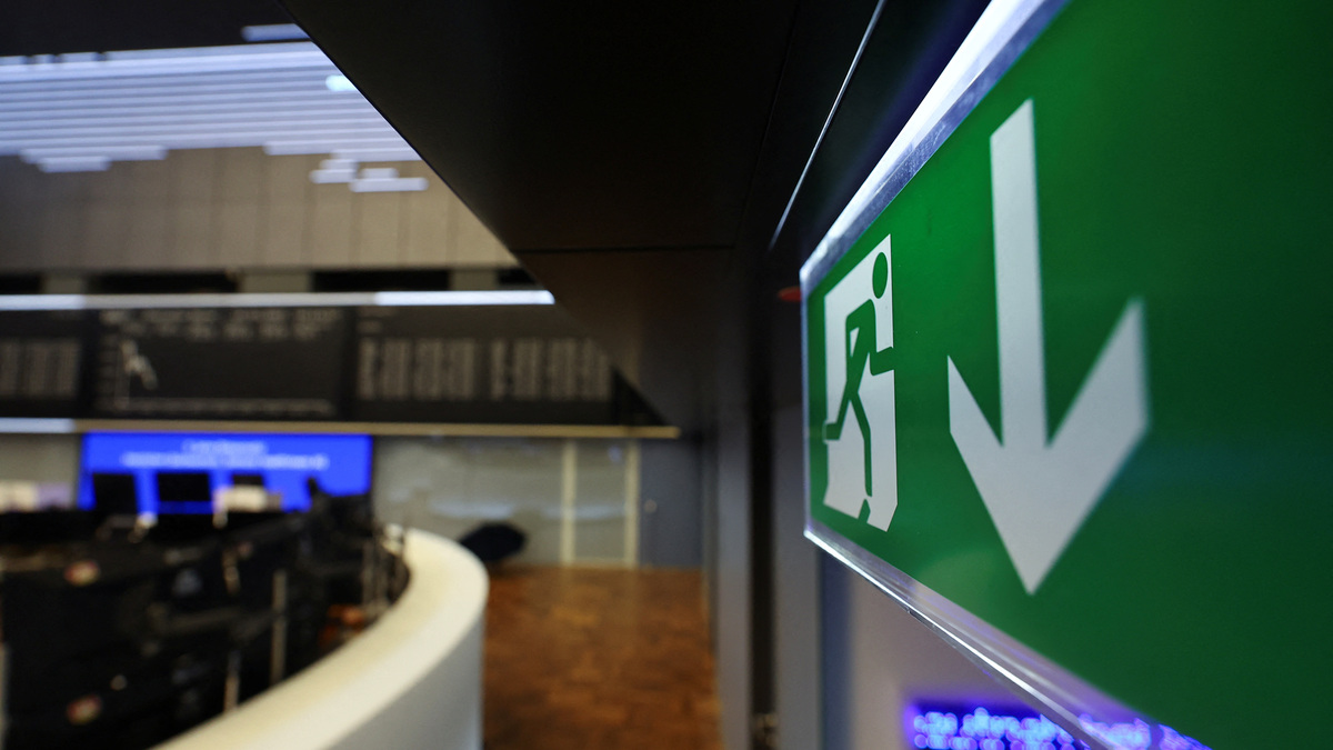 An emergency exit sign is seen near the DAX graph index board of the Frankfurt stock exchange following the shares of Credit Suisse hit a record low in a rout of European bank stocks, as investor concerns about sector stresses triggered by Silicon Valley Bank's implosion deepened, in Frankfurt, Germany, March 16, 2023. REUTERS/Kai Pfaffenbach