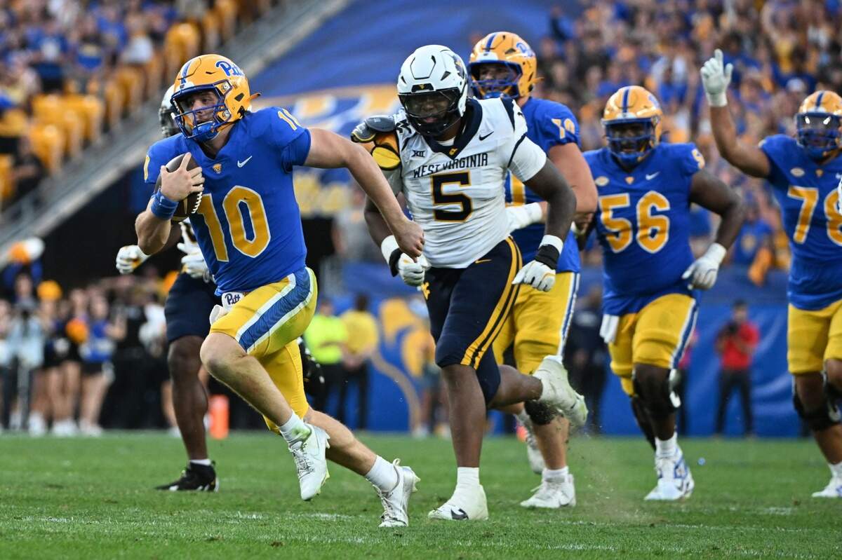 Sep 14, 2024; Pittsburgh, Pennsylvania, USA; Pittsburgh Panthers quarterback Eli Holstein (10) runs against West Virginia Mountaineers defensive lineman Sean Martin (5) during the fourth quarter at Acrisure Stadium.