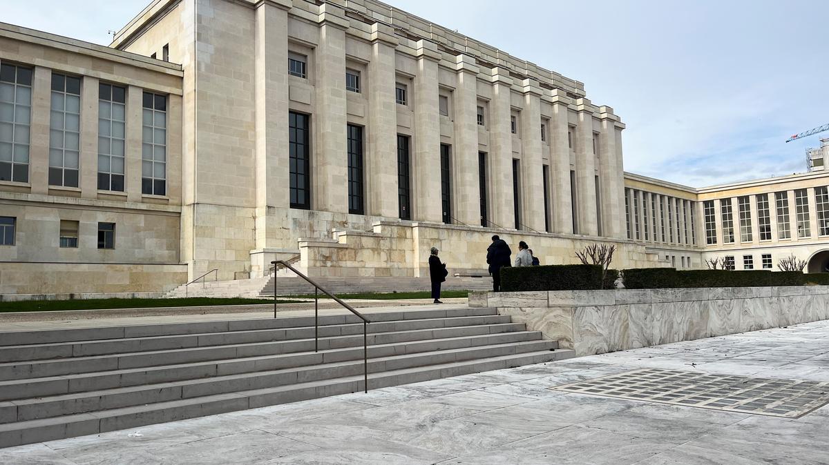 People stand in front of the Palais des Nations building, which serves as the European headquarters of the United Nations, in Geneva, Switzerland, March 16, 2026. Picture taken with a phone. REUTERS/Emma Farge