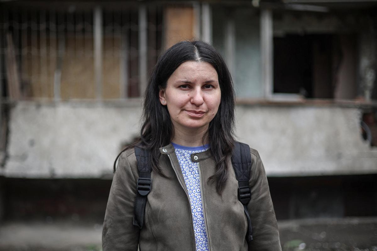 Olha Mudra, 35, a resident who survived yesterday's Russian missile and drone attack, poses for a photo in front of the residential building she lives in, which was damaged during the strike, amid Russia's attack on Ukraine, in Kyiv, Ukraine July 3, 2026. REUTERS/Alina Smutko