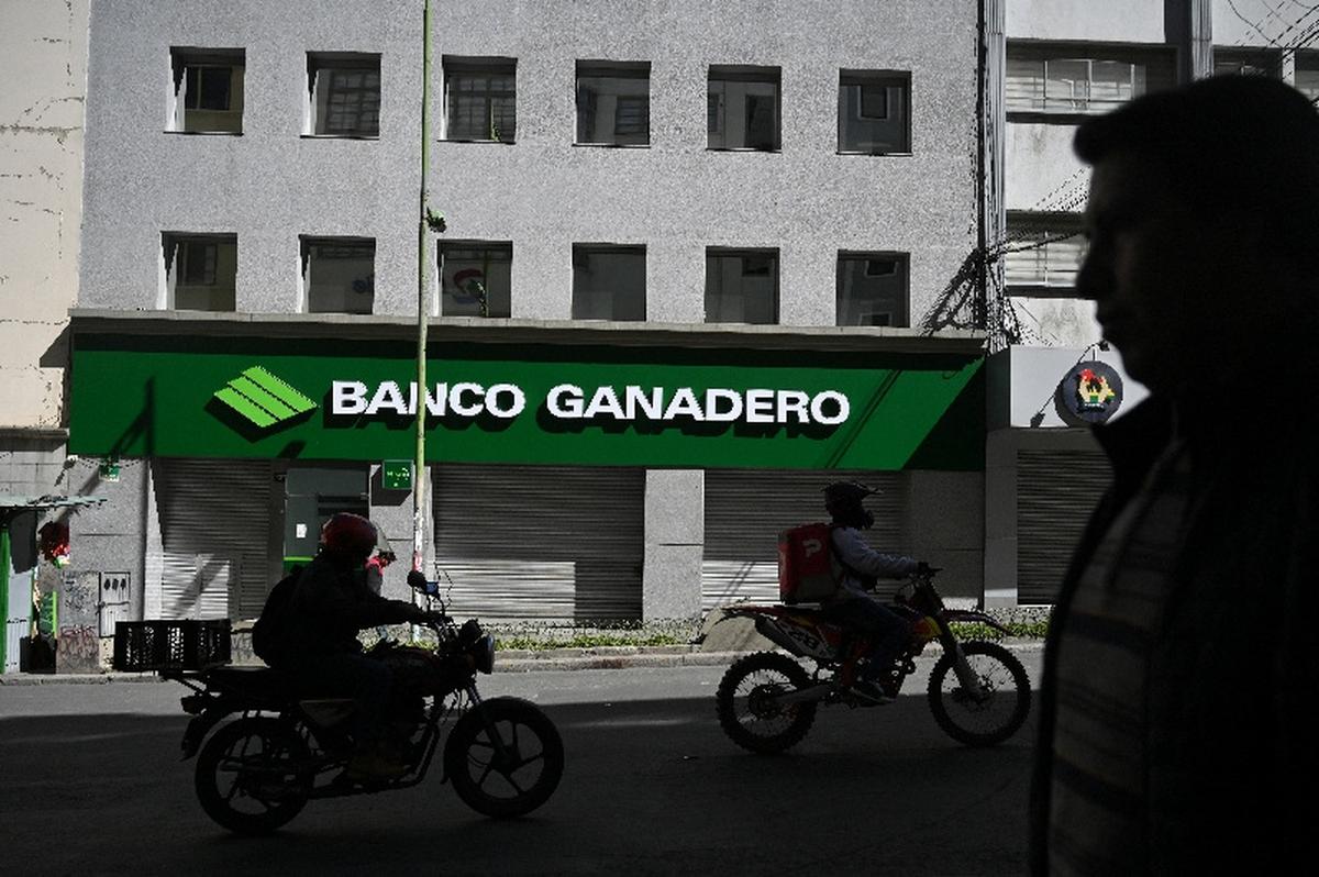 Motorcylists ride past a closed branch of the Banco Ganadero bank, as several Bolivian banks temporarily closed branches due to ongoing unrest driven by anti-government demonstrations, in La Paz, Bolivia, May 19, 2026. REUTERS/Claudia Morales