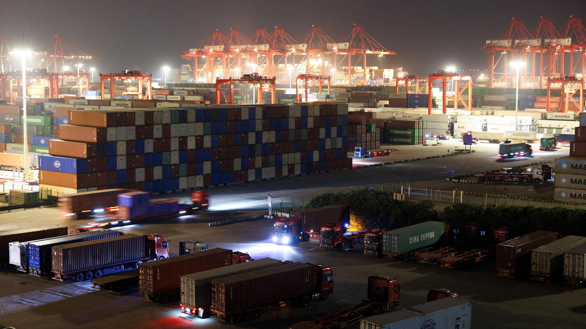 FILE PHOTO: Shipping containers are stacked while semi-trucks are parked at Yangshan Port outside Shanghai, China, May 7, 2026.  REUTERS/Go Nakamura/File Photo