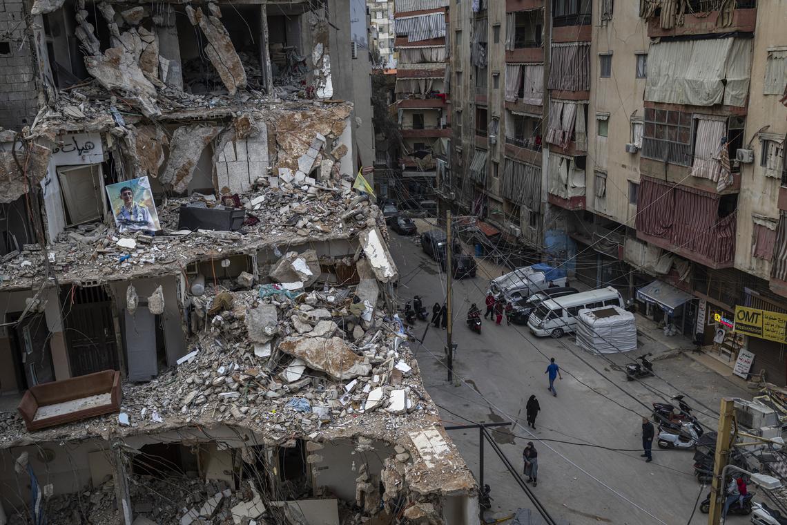 People walk near a building destroyed by airstrikes in the Hay El Sellom neighborhood of Beirut, Lebanon, following the announcement of a ceasefire, on Sunday, April 19, 2026. (Diego Ibarra Sánchez/The New York Times)