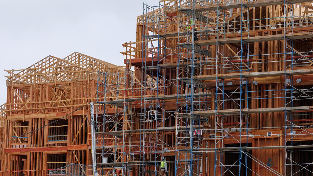 Construction crew members work on a multi-unit residential housing building in Encinitas, California, U.S., October 6, 2025.  REUTERS/Mike Blake/File Photo