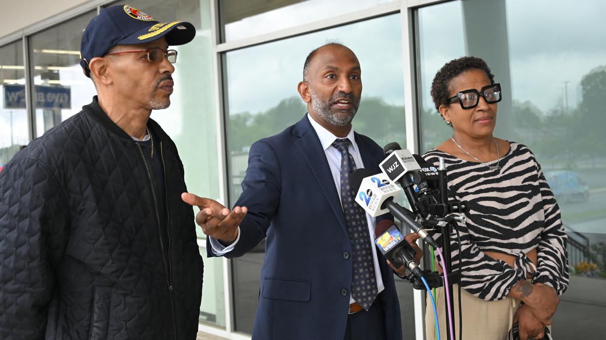 Belinda Curry, right, with attorney, Thiru Vignarajah, and her brother, James Munn, left, announce that the family has formally notified the City of Baltimore and the Baltimore City Board of School Commissioners of their intent to sue over an incident involving her son, Liam Livingston, on May 6, 2026. A year ago, almost to the day, six-year-old Liam succeeded in wandering off the premises of Fallstaff Elementary School completely unsupervised and not found until hours later. (Lloyd Fox/Baltimore Sun/TNS)