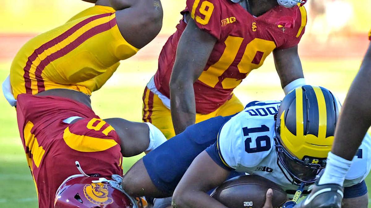  Oct 11, 2025; Los Angeles, California, USA; Michigan Wolverines quarterback Bryce Underwood (19) is stopped by USC Trojans defensive end Braylan Shelby (10) and safety Bishop Fitzgerald (19) after he ran the ball in the first half at United Airlines Field at the Los Angeles Memorial Coliseum. Mandatory Credit: Jayne Kamin-Oncea-Imagn Images | Jayne Kamin-Oncea-Imagn Images 