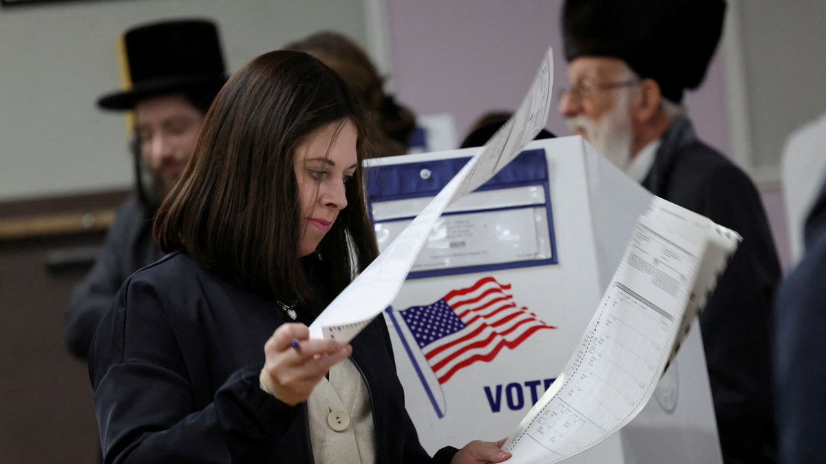 FILE PHOTO: FILE PHOTO: A woman checks over ballot papers at a polling center on Election Day in Brooklyn, New York City, U.S., November 5, 2024. REUTERS/Maye-E Wong/File Photo/File Photo