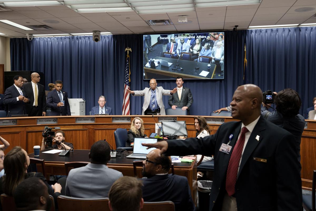 A member of the staff tries to calm the crowd during a public hearing on redistricting as Louisiana Republicans pursue a new congressional voting map ahead of the November midterm elections, in Baton Rouge, Louisiana, U.S., May 8, 2026. REUTERS/Wayan Barre