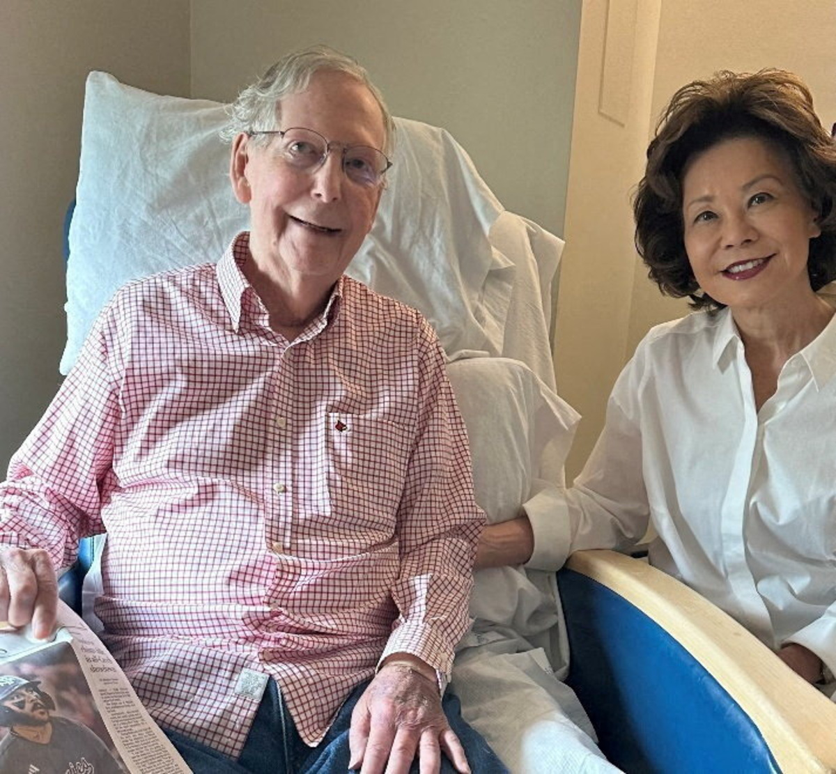 U.S. Senator Mitch McConnell (R-KY) sits with his wife, former United States secretary of labor Elaine Chao, while holding what appears to be the July 12 sports section of the Washington Post in a photograph released by his office in Washington, D.C., U.S. July 12, 2026.  Office of Senator Mitch McConnell/Handout via REUTERS.    THIS IMAGE HAS BEEN SUPPLIED BY A THIRD PARTY
