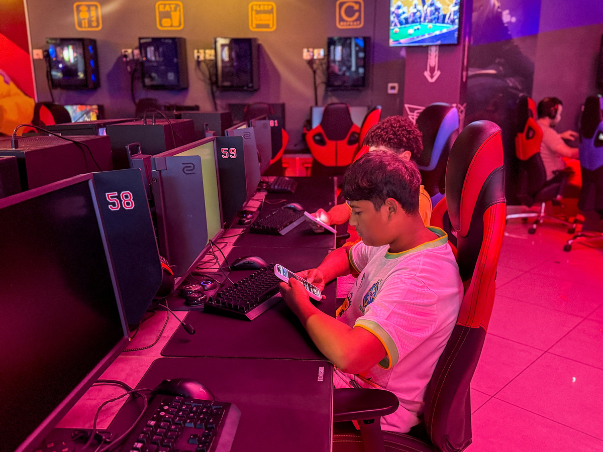 Boys look at their mobile phones at a gaming centre, after the United Arab Emirates approved a resolution setting the minimum age for social media use at 15, in Dubai, United Arab Emirates, June 18, 2026. Picture taken with a mobile phone. REUTERS/Rula Rouhana