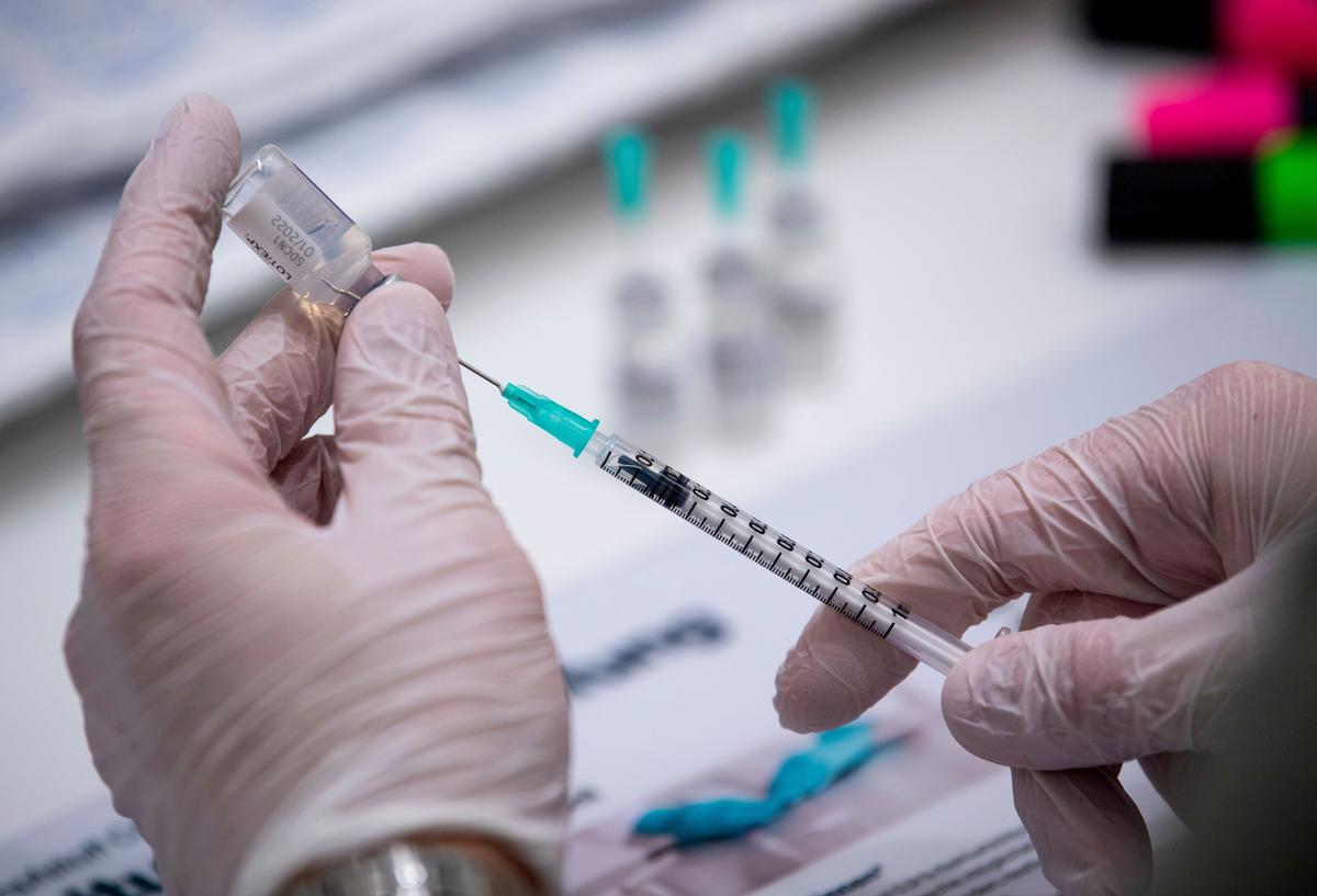 An employee of the vaccination campaign prepares Biontech doses against the COVID-19 disease in Osnabueck, Germany, Saturday, Nov. 13, 2021. Germany has struggled to bring new momentum to its vaccination campaign lately, with a bit over two-thirds of the population fully vaccinated, and has balked so far at ordering vaccine mandates for any professional group.