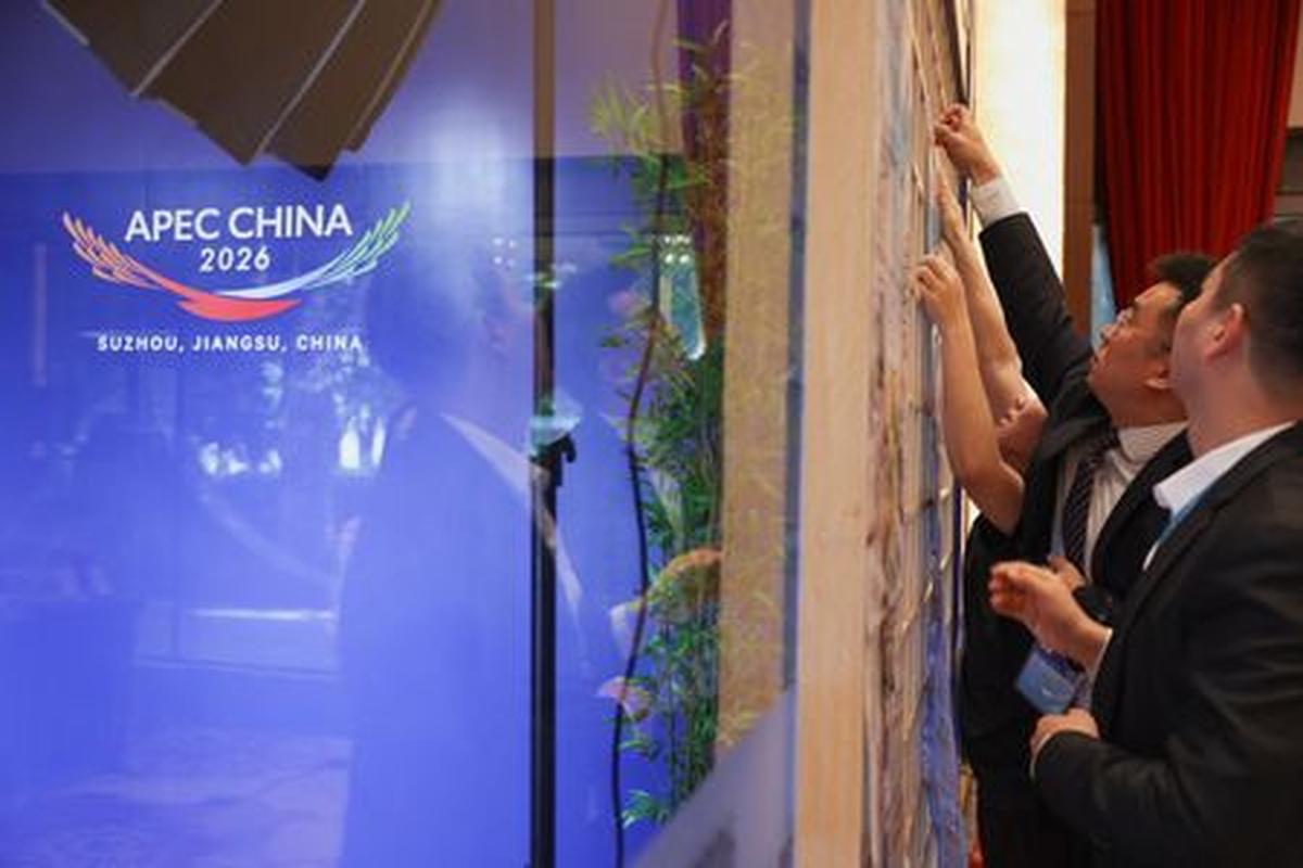 Staff and volunteers put up a poster in the media center during the APEC China 2026 Ministers Responsible for Trade (MRT) meeting in Suzhou, Jiangsu Province, China, May 22, 2026.  REUTERS/Go Nakamura