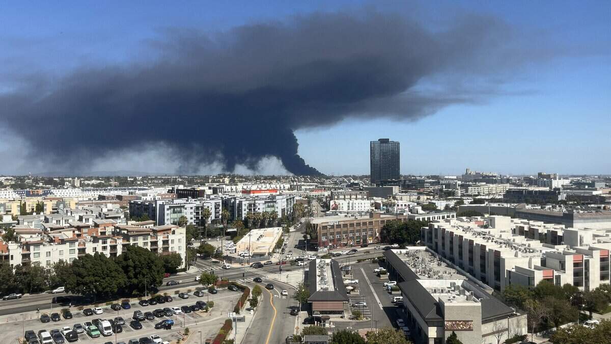 Black smoke rises from a warehouse fire in Boyle Heights as seen from downtown Los Angeles on June 17, 2026. The fire continued to spew dangerous fumes across the area on Saturday.