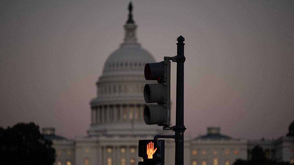 A crosswalk signal of a traffic light flashes backdropped by the U.S. Capitol in Washington, D.C., on Oct. 1, 2025, the first day of the U.S. federal government shutdown.