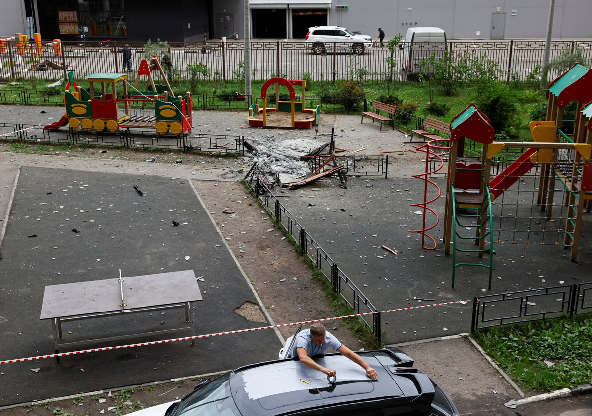 A man tapes up the roof of a car next to a damaged apartment building following a Ukrainian drone attack in the course of Russia-Ukraine conflict in Zhukovsky in the Moscow region, Russia June 18, 2026. REUTERS/Stringer