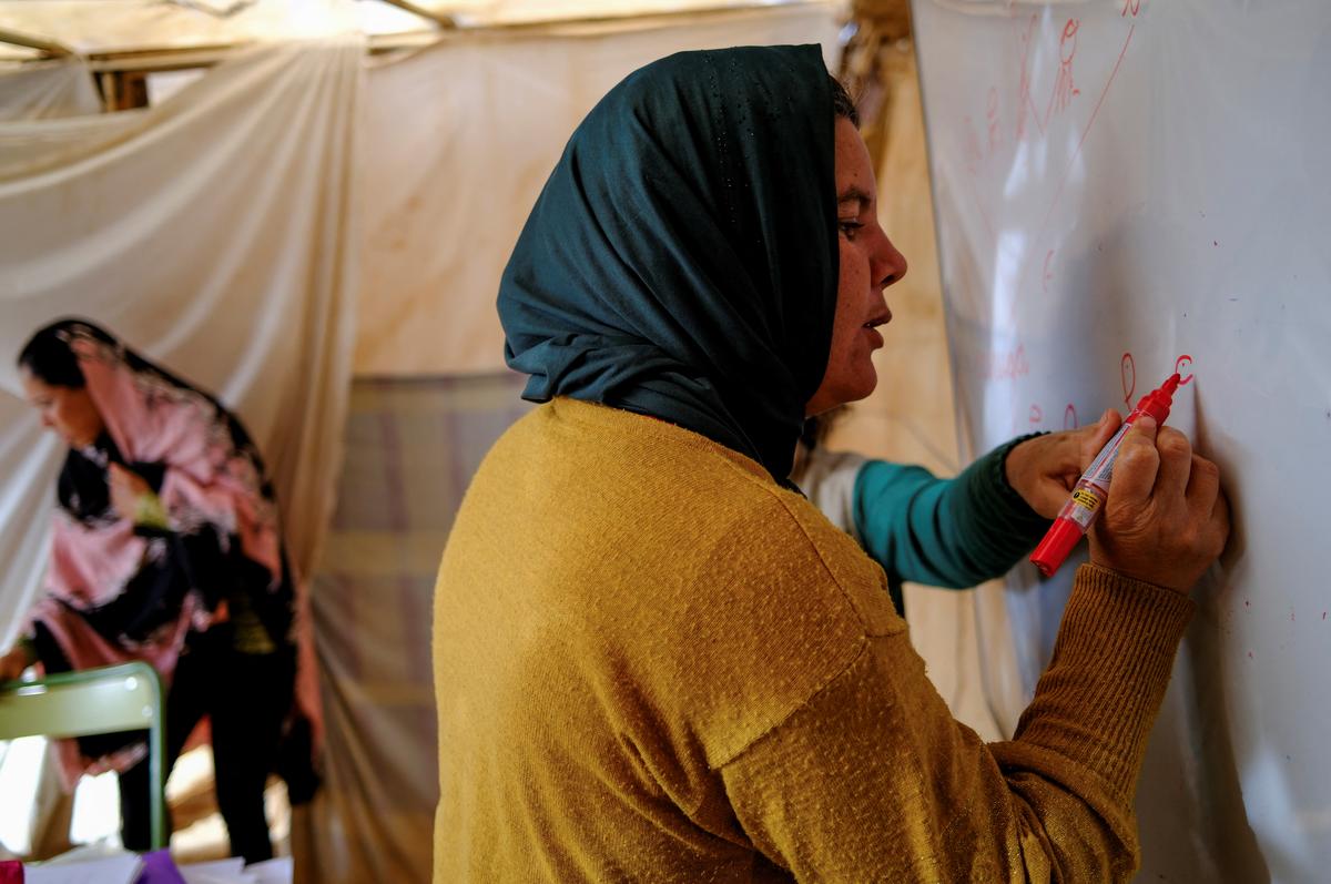 Undocumented migrants from Morocco attend Spanish classes taught by members of the Jesuit Migrant Service in a shanty town after returning of their work inside a plastic-covered greenhouse in Almeria province, home to Europe’s largest concentration of agricultural greenhouses, in Nijar, Spain, May 5, 2026. Undocumented migrants there live without reliable electricity and with limited access to water. REUTERS/Nacho Doce