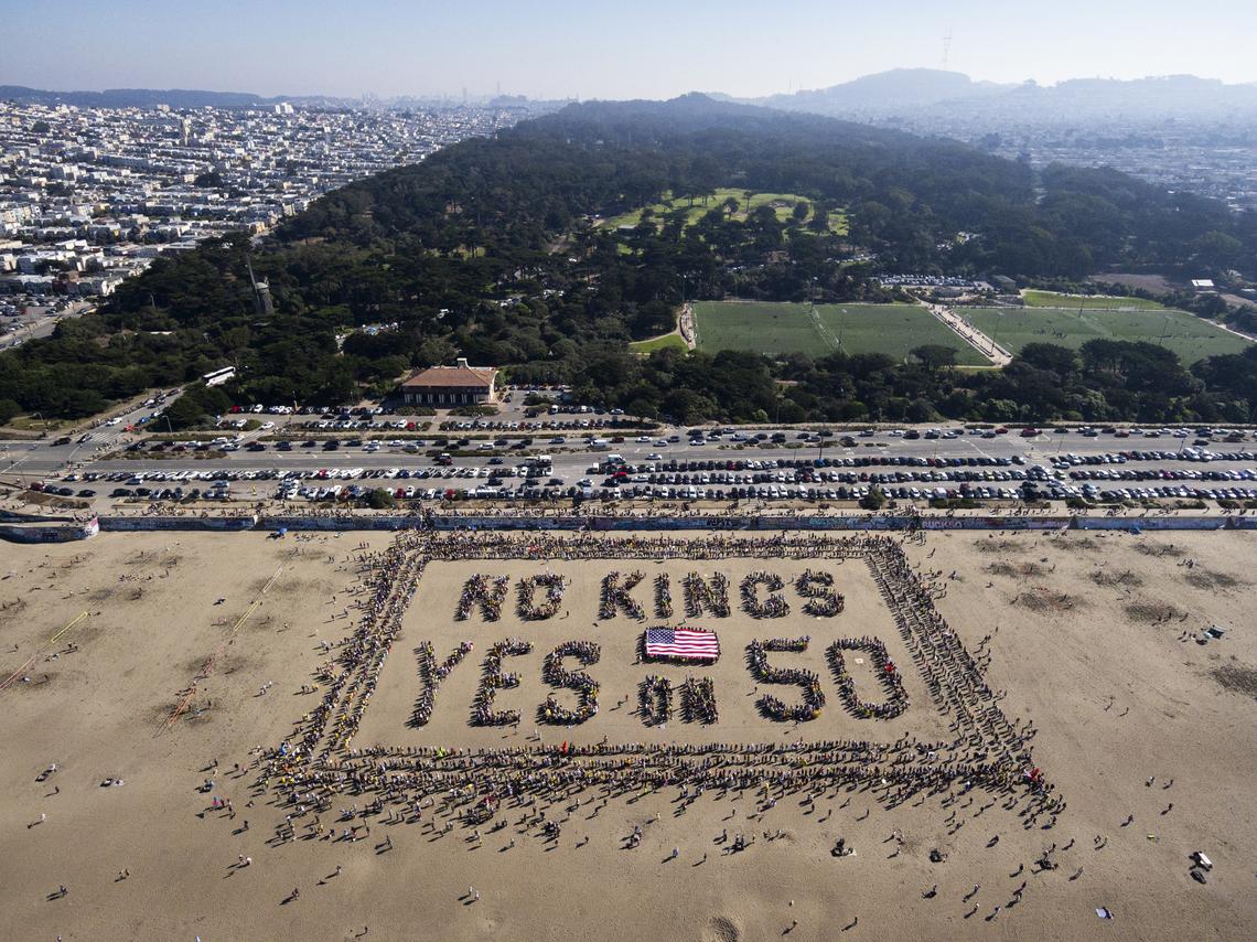 This aerial picture taken Oct. 18 shows protesters forming a human banner during the "No Kings" national day of protest on Ocean Beach in San Francisco.