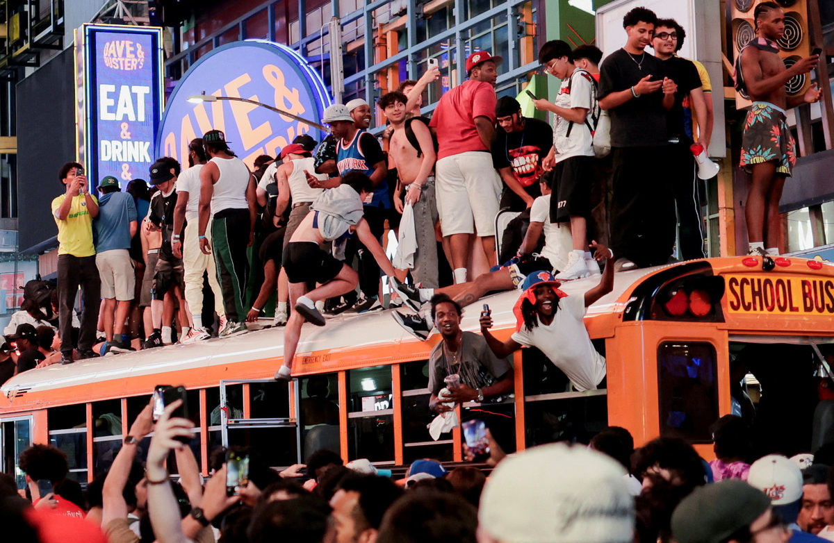 Fans celebrate the New York Knicks' win against the San Antonio Spurs in Game 5 of the NBA Finals at Times Square, in New York City, U.S., June 13, 2026. REUTERS/Jeenah Moon