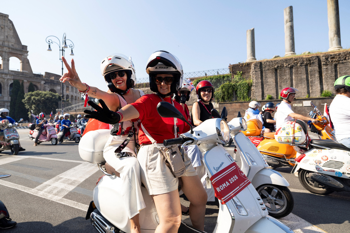 Vespa riders gesture as they drive near the Colosseum the last day of “Vespa Roma 2026 - 80 Years of an Icon”, a four-day global gathering marking the 80th anniversary of the iconic Italian scooter brand, in Rome, Italy, June 27, 2026. REUTERS/Remo Casilli