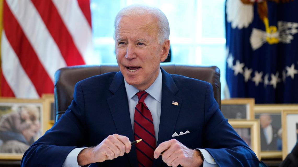 FILE - In this Jan. 28, 2021 file photo, President Joe Biden signs a series of executive orders in the Oval Office of the White House in Washington. Biden’s $1.9 trillion coronavirus pandemic relief bill includes billions that would go to Kansas and Missouri. (AP Photo/Evan Vucci)