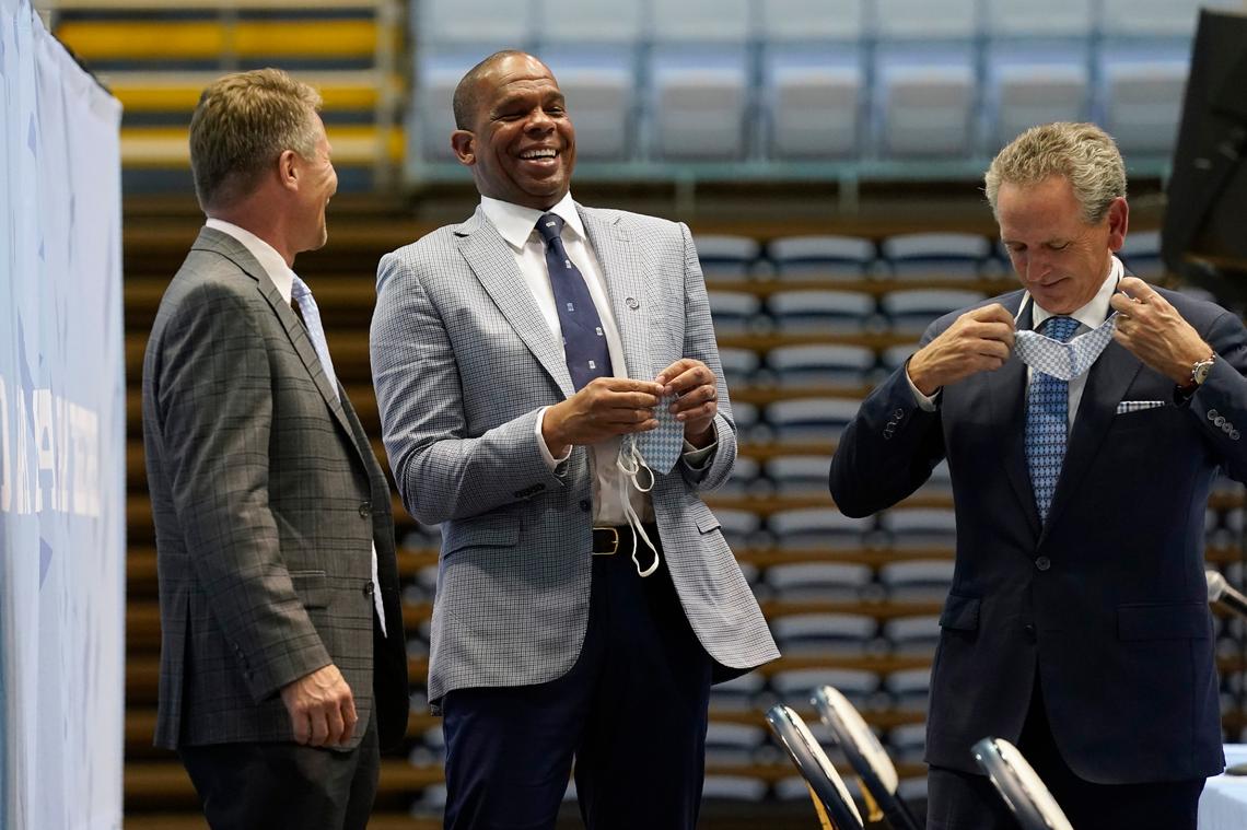 North Carolina head coach Hubert Davis, center, laughs with chancellor Kevin Guskiewicz, left, and athletic director Bubba Cunningham following a news conference at the University of North Carolina in Chapel Hill, N.C., Tuesday, April 6, 2021. Davis was named the Tar Heels new NCAA men’s basketball coach following the retirement of Roy Williams.