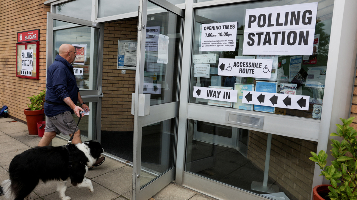 A man, with his dog, arrives to vote in the Makerfield by-election, triggered by the resignation of Labour MP John Simons, at St. Aidan's Parish Centre, in Winstanley, Wigan, Britain, June 18, 2026. REUTERS/Temilade Adelaja