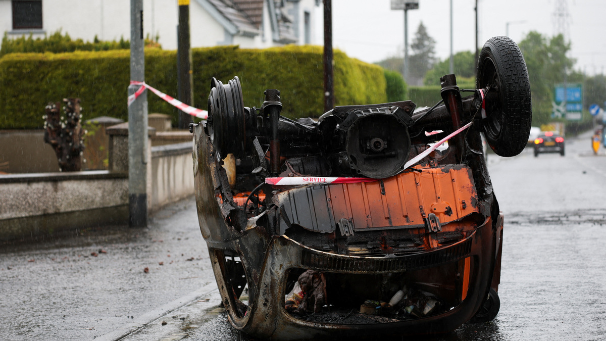 A burnt car lies at Antrim Road, in the aftermath of anti-immigrant protests following a knife attack on June 8, which left a man seriously injured and prompted police to declare a critical incident, in Belfast, Northern Ireland, June 11, 2026. REUTERS/Isabel Infantes