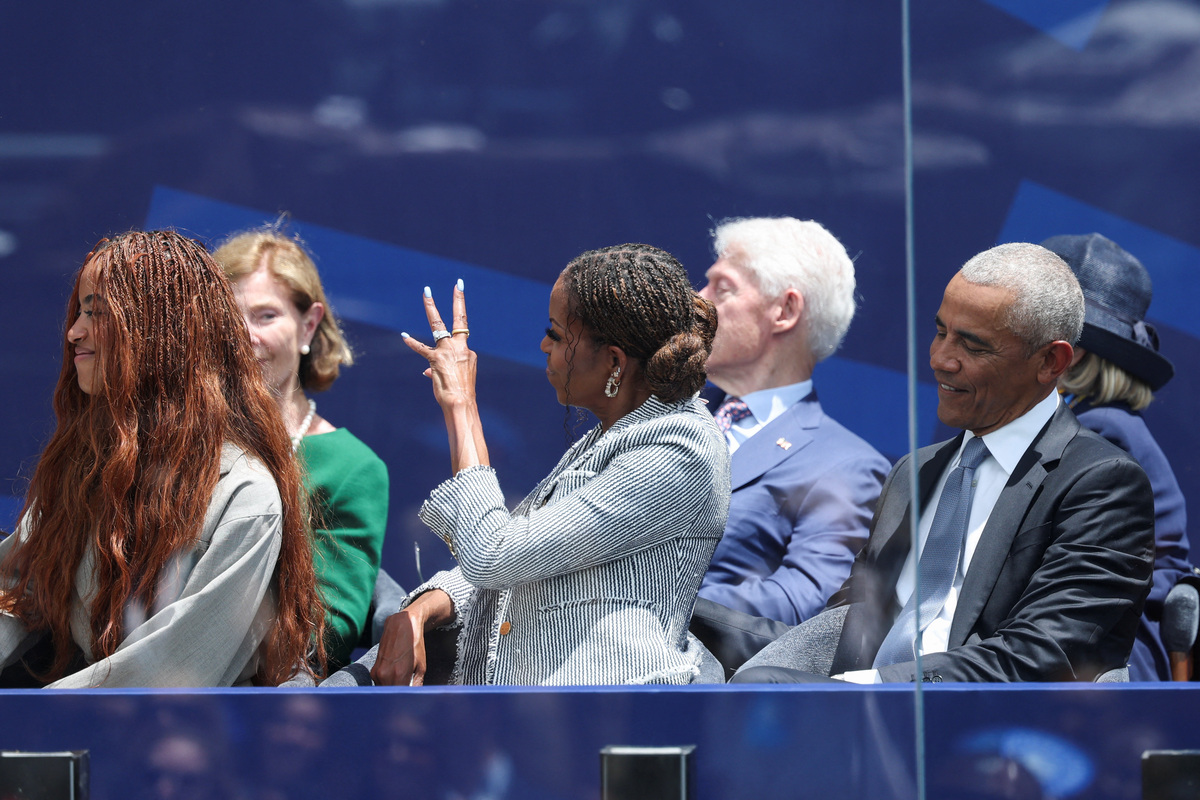 Former U.S. first lady Michelle Obama greets Bono of U2 as he performs during a dedication ceremony for the opening of the Obama Presidential Center, accompanied by former U.S. President Barack Obama, Malia Obama, former first lady Laura Bush, former U.S. President Bill Clinton and former U.S. Secretary of State Hillary Clinton, in Chicago, Illinois, U.S., June 18, 2026. REUTERS/Brendan McDermid