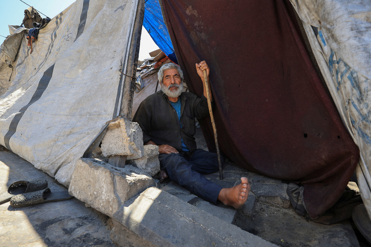 A displaced Palestinian man looks on as she sits in his tent shelter in Gaza City, June 15, 2026. REUTERS/Dawoud Abu Alkas