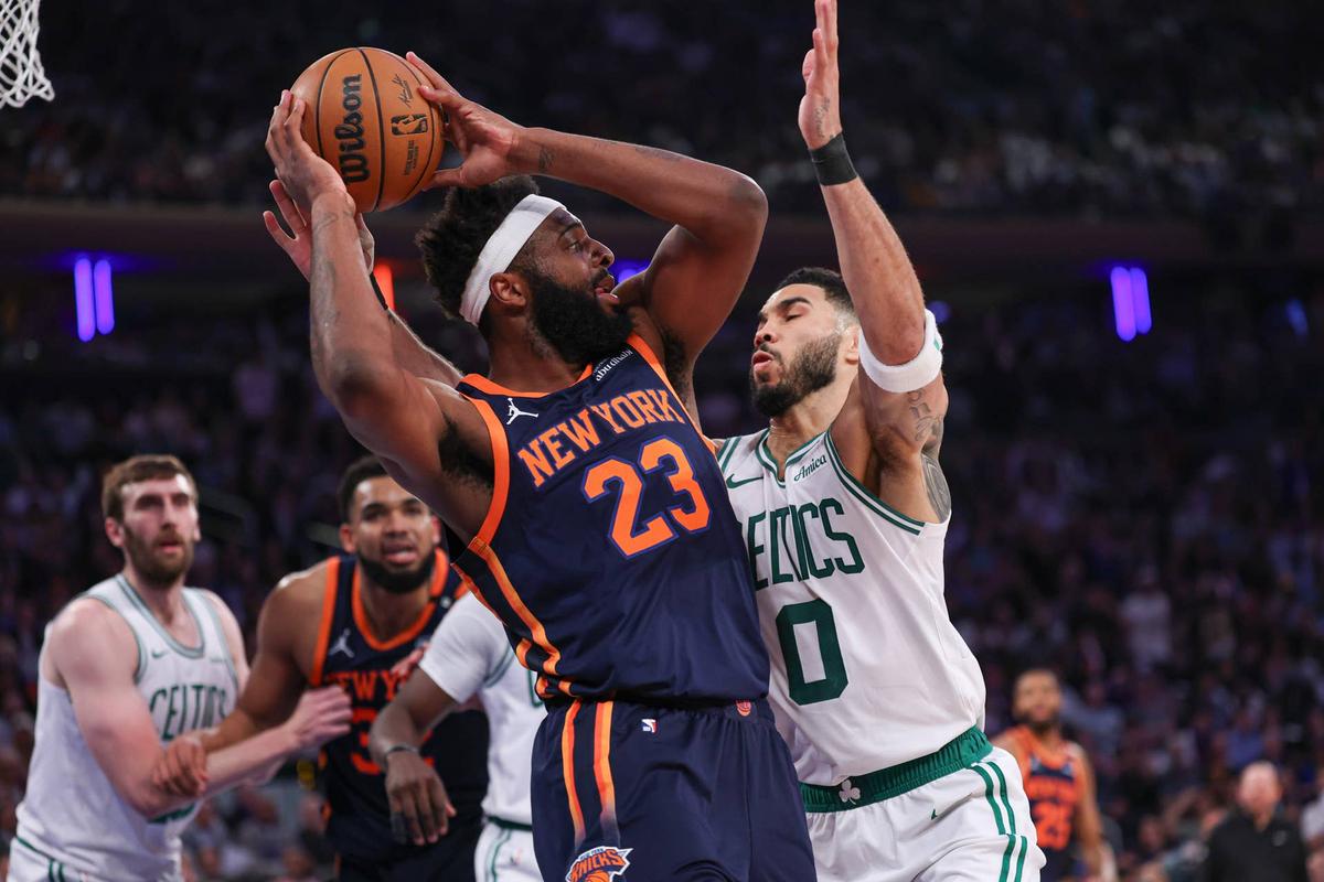  New York Knicks center Mitchell Robinson (23) looks to pass after a rebound as Boston Celtics forward Jayson Tatum (0) defends in the first half on May 12, 2025. 
