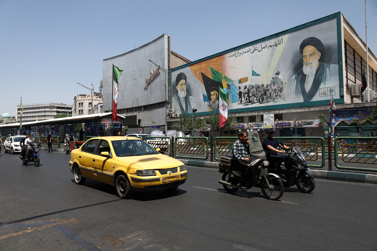 People ride past a mural depicting the late leader of the Islamic Revolution, Ayatollah Ruhollah Khomeini, and the late Iran's Supreme Leader Ayatollah Ali Khamenei, on a street in Tehran, Iran, June 9, 2026. Majid Asgaripour/WANA (West Asia News Agency) via REUTERS