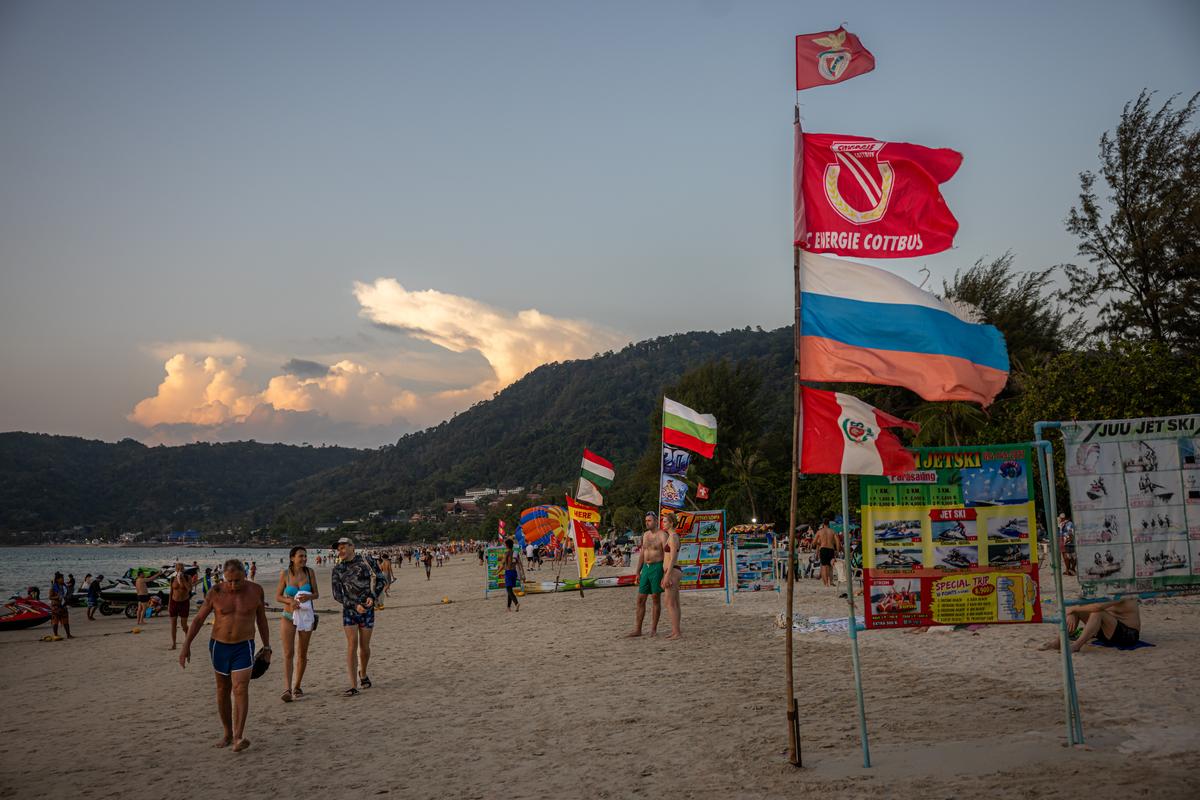 A business flies a Russian flag to attract visitors along Patong Beach in Phuket, Thailand on March 8, 2026. Thousands who fled Russia after the invasion of Ukraine have built an enclave in Phuket, where an air of impermanence hangs over their community. (Lauren DeCicca/The New York Times)..
