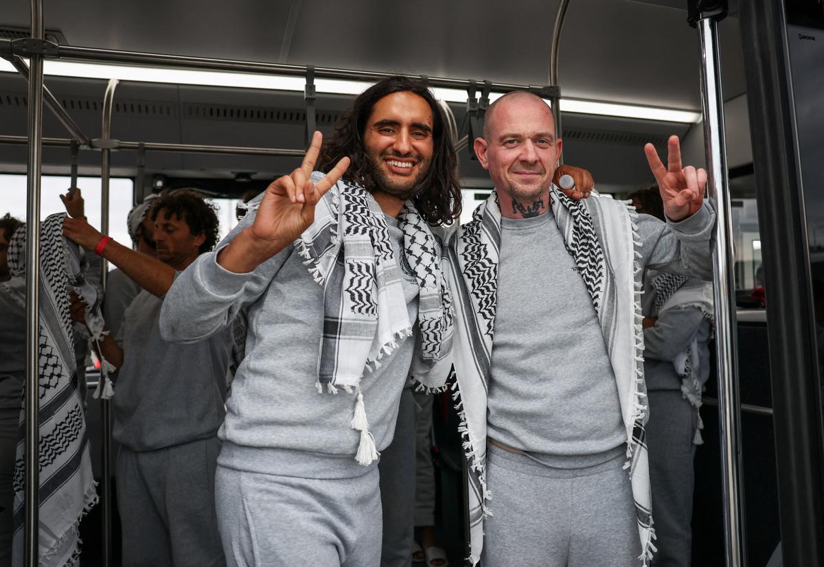 A Moroccan activist from the Gaza-bound Global Sumud Flotilla, detained by Israeli forces after their vessels were intercepted in international waters in the Mediterranean, gestures with an Irish activist upon their arrival at Istanbul Airport, Turkey, May 21, 2026. REUTERS/Murad Sezer