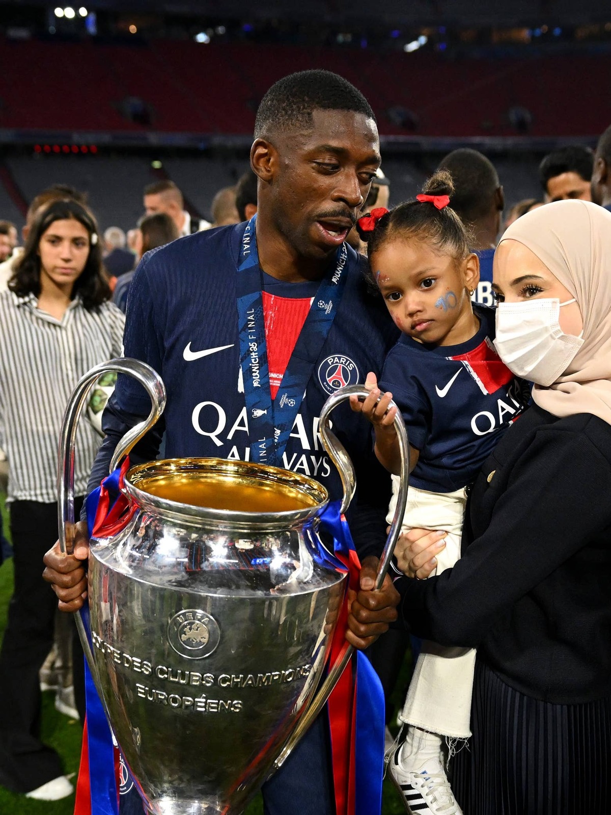  Ousmane Dembele of Paris Saint-Germain poses for a photograph with the UEFA Champions League trophy alongside his wife Rima Edbouche and daughter after his team's victory, to secure Paris Saint-Germain's first ever UEFA Champions League title in the club's history and a record UEFA Champions League Final winning scoreline of 5-0, following the UEFA Champions League Final 2025 between Paris Saint-Germain and FC Internazionale Milano at Munich Football Arena on May 31, 2025 in Munich, Germany. (Photo by Michael Regan - UEFA/UEFA via Getty Images) Photo by Michael Regan - UEFA/UEFA via Getty Images