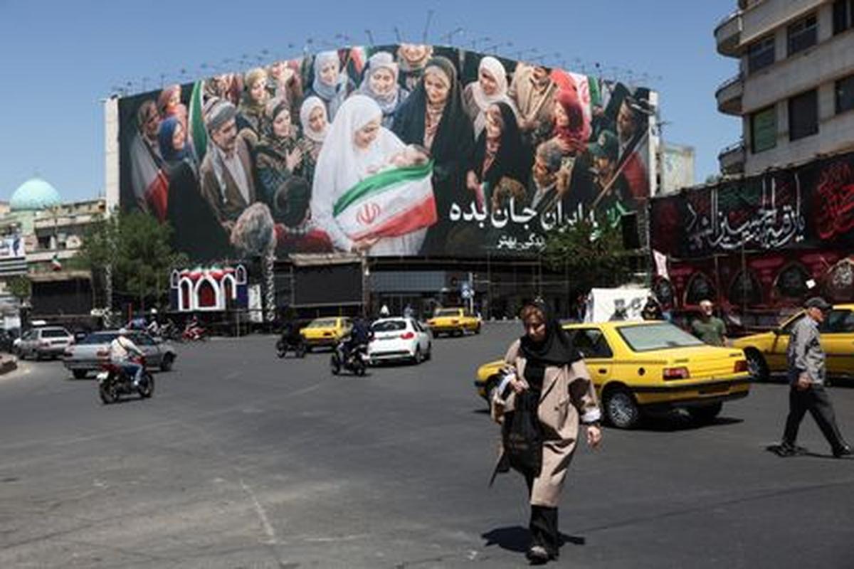 People walk past a billboard with a picture of Iranian people, in Tehran, Iran, May 25, 2026. Majid Asgaripour/WANA (West Asia News Agency) via REUTERS