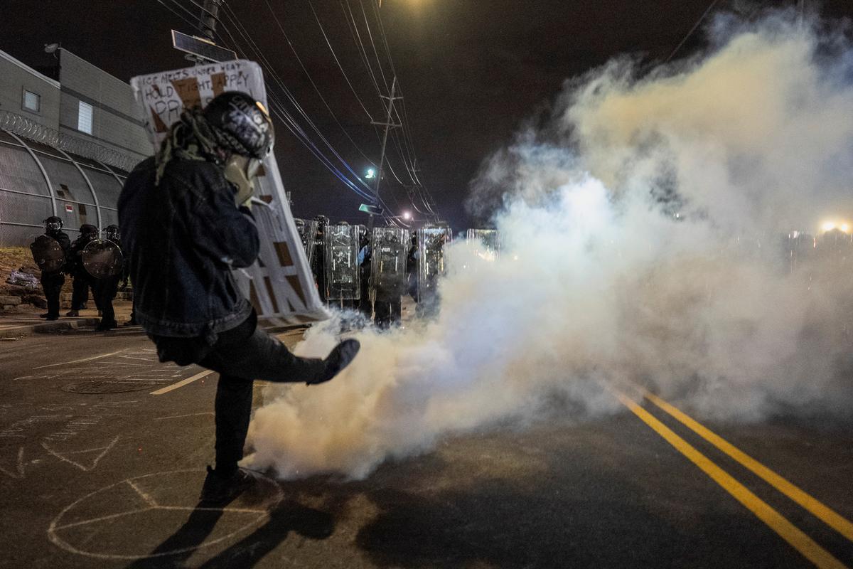 A demonstrator kicks away a tear gas cannister as New Jersey State Policemen in riot gear stand guard nearby, during a protest outside Delaney Hall detention center, in Newark, New Jersey, U.S., May 29, 2026. REUTERS/David Delgado