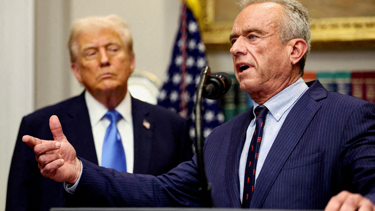 FILE PHOTO: U.S. Secretary of Health and Human Services Robert F. Kennedy Jr. delivers remarks while U.S. President Donald Trump listens during a press conference to announce a link between autism and childhood vaccines and the use of popular pain medication Tylenol for pregnant women and children, claims which are not backed by decades of science, at the White House in Washington, D.C., U.S., September 22, 2025. REUTERS/Kevin Lamarque/File Photo