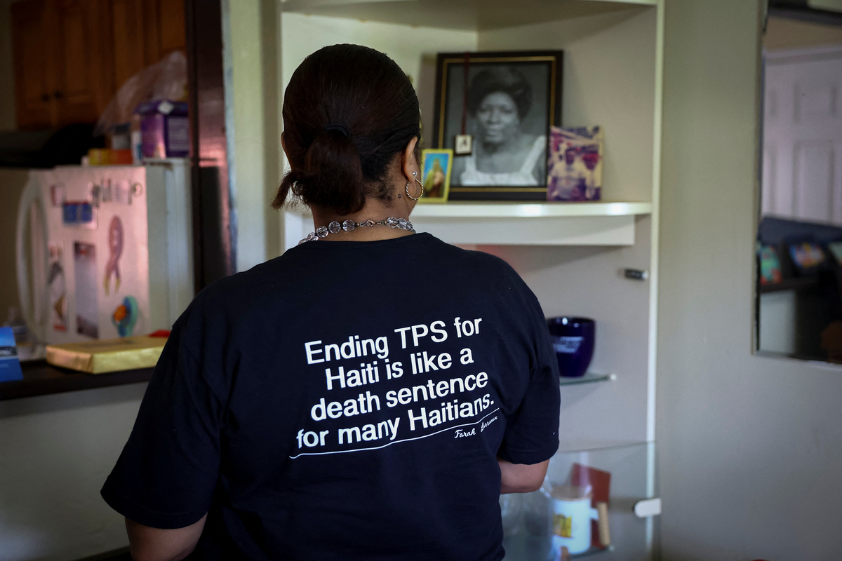 A detail of a message on the t-shirt of Farah Larrieux, a Temporary Protected Status (TPS) holder, as she speaks during an interview with Reuters, in Miami, Florida, U.S., June 28, 2026. REUTERS/Marco Bello