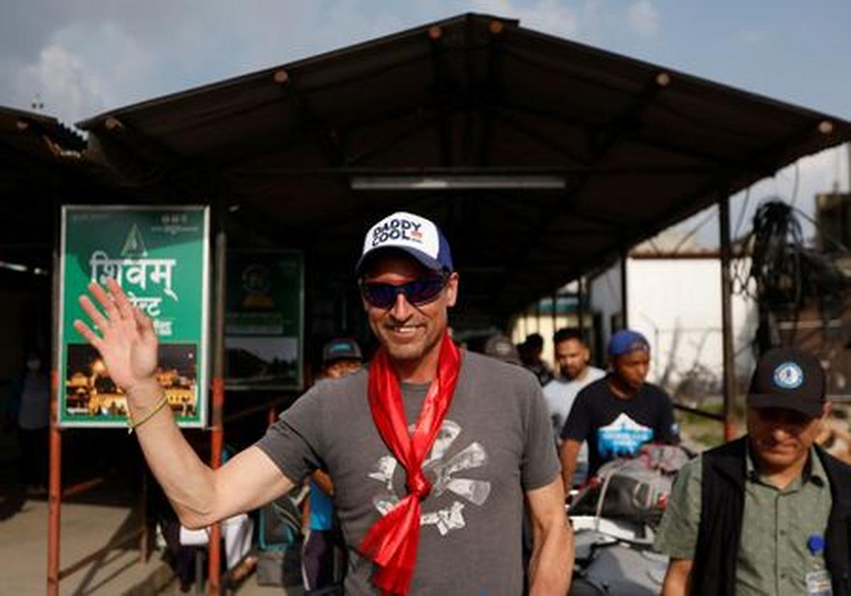 British climber Kenton Cool, 49, waves towards the media personnel, upon his arrival at the airport, as he returns after completing his 17th ascent of Mount Everest, which is the most by any foreign climber, in Kathmandu, Nepal May 19, 2023. REUTERS/Navesh Chitrakar